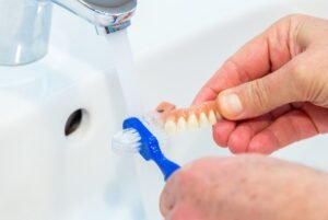 Using a denture brush to clean dentures